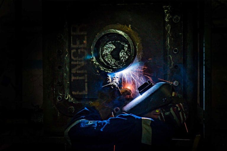 On-station repairs man using welder in the dark