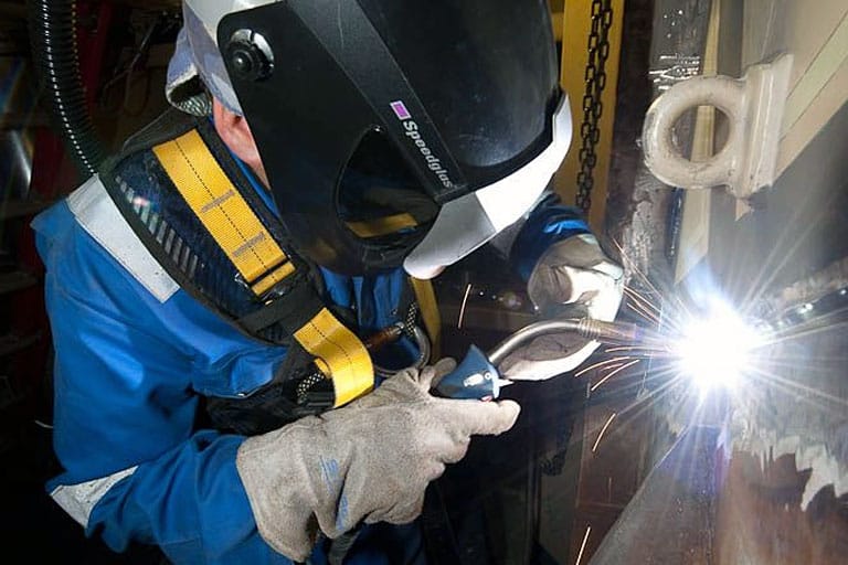 On-station repairs by a man using a welder