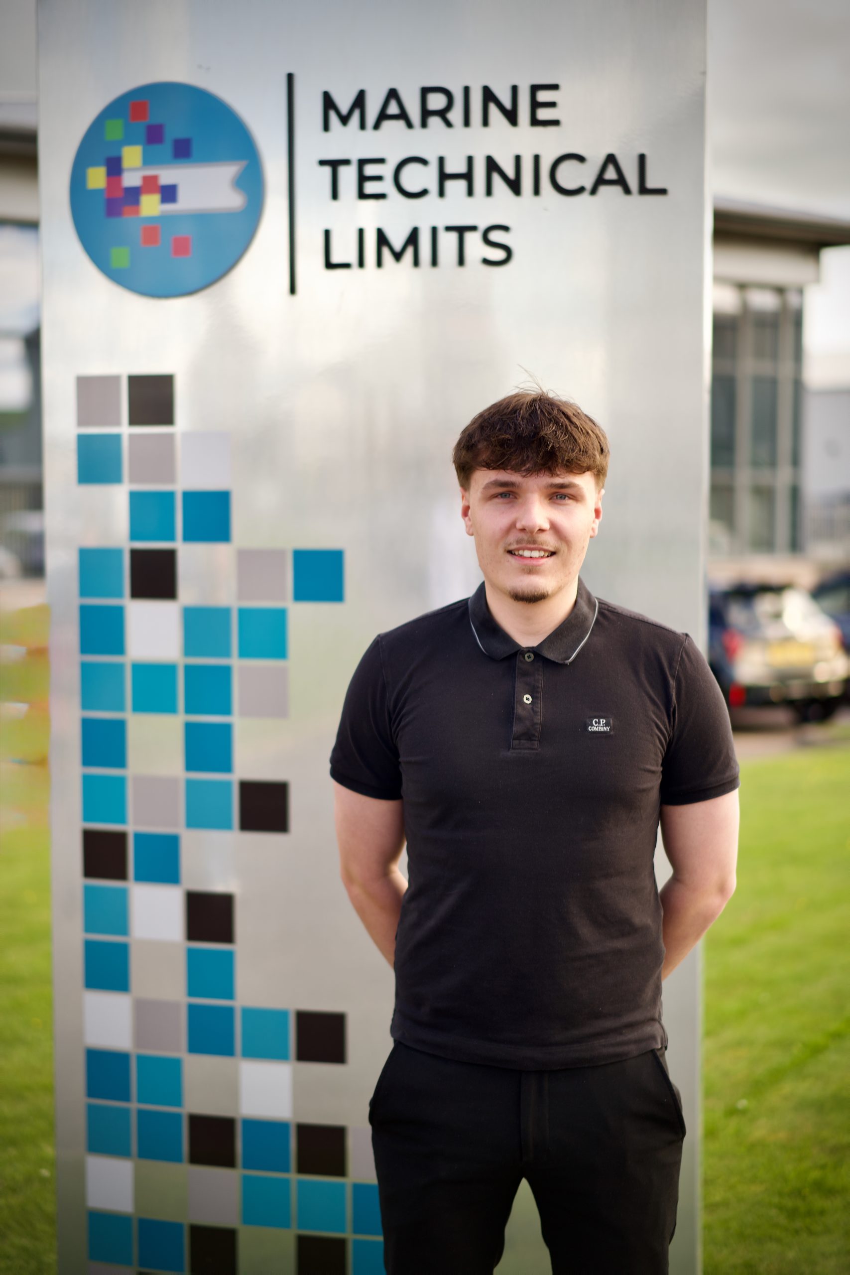 student standing next to company sign