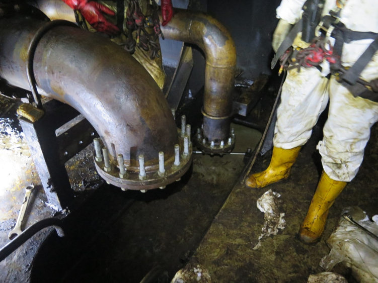 An FPSO Inspector clothed in protective clothing carrying out cleaning and repairs