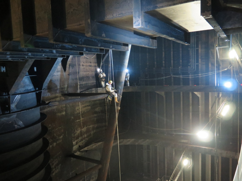 FPSO Inspectors conducting inspection and repairs suspended from ropes, with the tank lit by ATEX LED lights