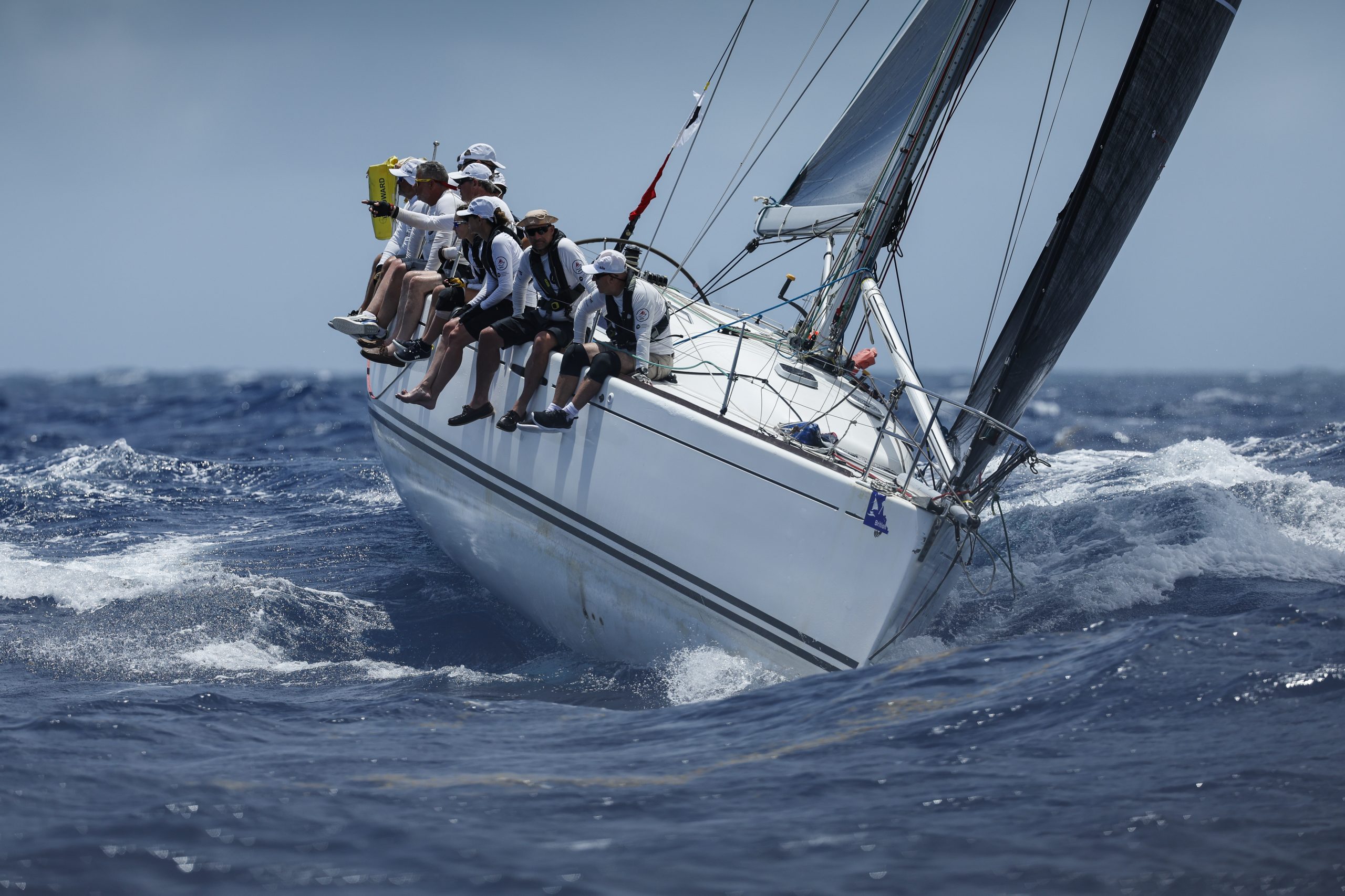 Large yacht sailing the high seas in bright sunshine and other crew members